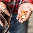 Un hombre sostiene en su mano un puñado de monedas