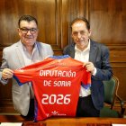 Patricio de Pedro y Benito Serrano con la camiseta del Numancia tras la firma de la renovación del convenio de colaboración.