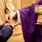 Un sacerdote dando la comunión a un feligrés en una imagen reciente.