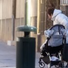 Una mujer junto a un carrito de bebé.