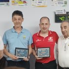 Carlos Cortés, con camiseta roja, con el trofeo de su último triunfo.