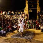 Uno de los pasadores con la móndida a su espalda cruzando la alfombra de brasas.