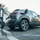 Vehículo eléctrico moderno cargando en una estación exterior
