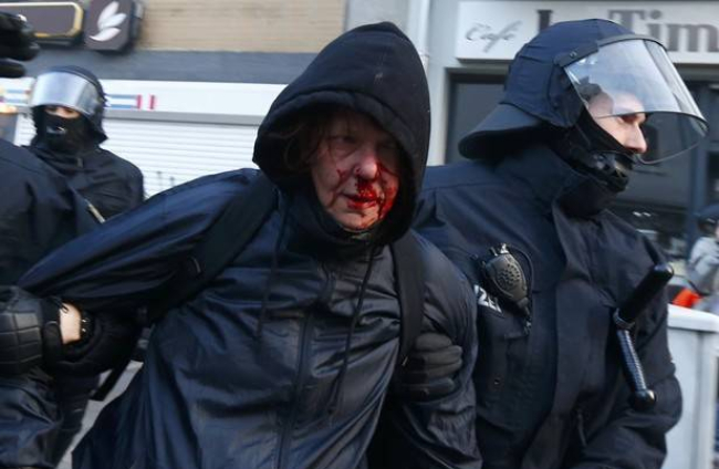 La policía detiene a un manifestante 'Blockupy' herido en la cara. MICHAEL DALDER | REUTERS