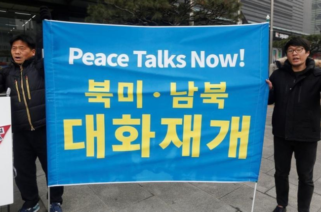 Manifestantes surcoreanos sostienen una pancarta que exige negociaciones de paz con Corea del Norte durante una protesta en Seúl.-EFE / JEON HEON-KYUN