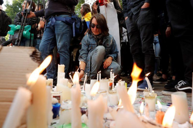 Un hombre enciende una vela como homenaje al joven Dilan Cruz en la calle en la que resulto herido el pasado sábado, durante una nueva jornada de protestas y movilizaciones antigubernamentales, que completan seis días este martes, en Bogotá (Colombia).-EFE