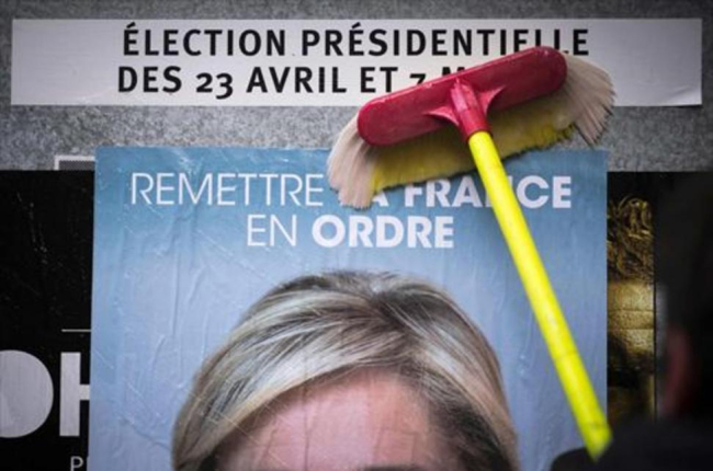 Un empleado del Frente Nacional pega un cartel electoral de Marine Le Pen al inicio de la campaña.-AFP / LIONEL BONAVENTURE