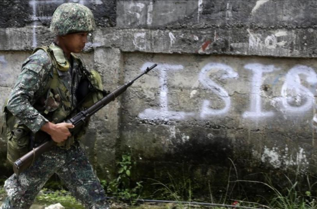 Un soldado filipino patrulla por un vecindario despues de un bombardeo durante los combates contra el EI.-FRANCIS R MALASIG