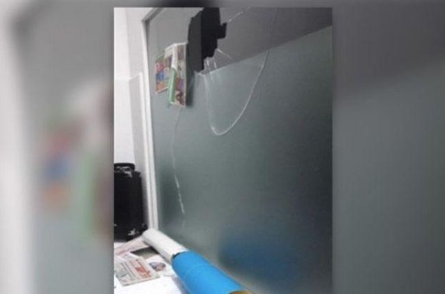 Imagen de cómo ha quedado la cristalera de la sede de Podemos en La Línea tras el ataque con una piedra.-EUROPA PRESS