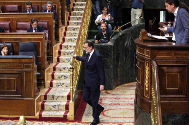 Mariano Rajoy vuelve a su escaño durante la intervención de Pablo Iglesias en la moción de censura.-JUAN MANUEL PRATS
