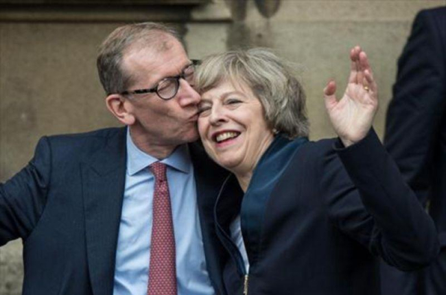 Theresa May recibe un beso de su marido, Philip John May, en el Palacio de Westminster-AFP / CHRIS RATCLIFFE