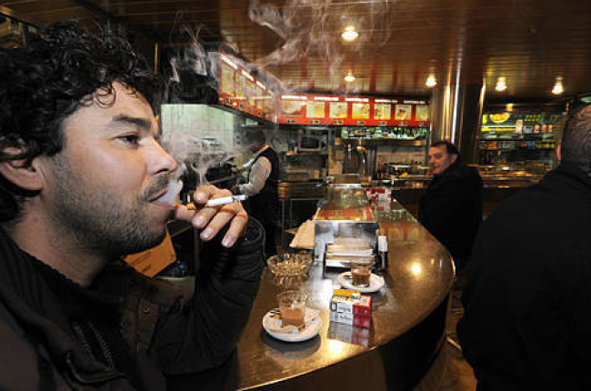 Dos clientes fumaban ayer en un bar en las últimas horas antes de la prohibición. La imagen ya es historia / V. GUISANDE-
