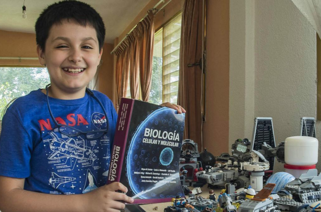 Carlos Antonio, con un libro de biología y sus construcciones de Lego /-UNAM