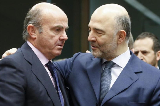 El ministro espanol de Economia, Luis de Guindos, conversa con el comisario europeo de Asuntos Economicos, Pierre Moscovici.-EFE / OLIVIER HOSLET