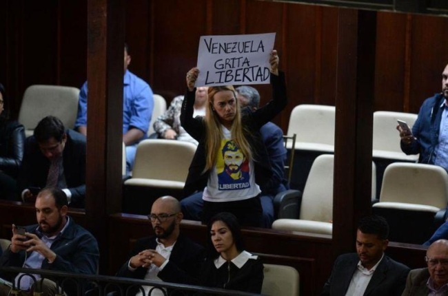 La activista Lilian Tintori, esposa del arrestado opositor venezolano Leopoldo López, muestra una pancarta contra Maduro en la Asamblea Nacional de Venezuela.-FEDERICO PARRA (AFP)