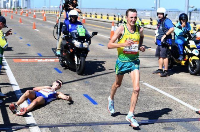 El escocés Hawkins, tendido en el asfalto, tras sufrir un colapso en el maratón disputado en Australia.-EFE / TRACEY NEARMY
