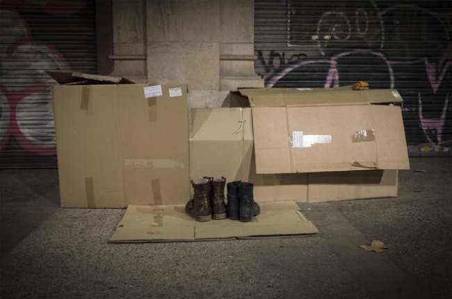 Un mendigo duerme en la calle de una ciudad española.-JOAN CORTADELLAS