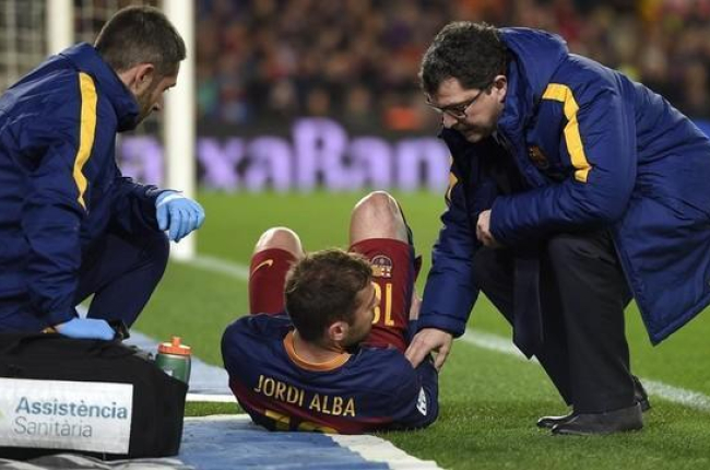 Jordi Alba es atendido tras su lesión muscular por el doctor Ricard Pruna (derecha).-AFP / LLUIS GENE