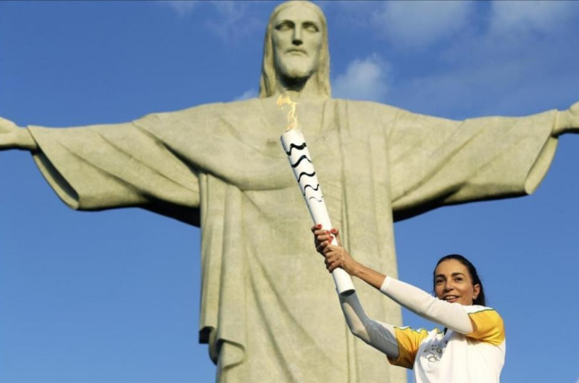 La exjugadora de voleibol brasileña Isabel Barroso, con la antorcha ante el Cristo Redentor de Corcovado.-EFE / FERNANDO MAIA