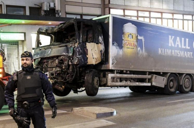 La policía retira, este viernes por la noche, el camión con el que un terrorista perpetró un atentado en el centro de Estocolmo.-EFE / MAJA SUSLIN