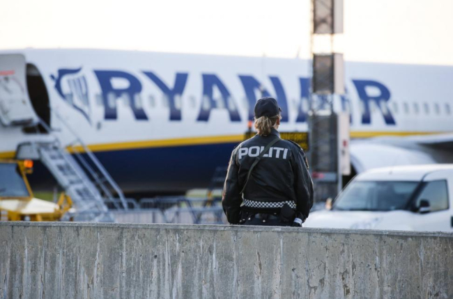Un agente de policía, frente al avión de Ryanair evacuado, el domingo en el aeropuerto noruego de Moss-Rygge.-AP / HAAKON MOSVOLD