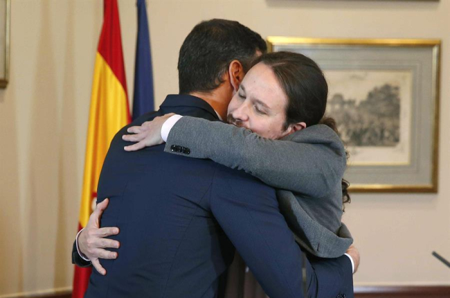 El presidente del Gobierno español en funciones, el socialista Pedro Sánchez, iz., y el líder de Unidas Podemos, Pablo Iglesias,d., se abrazan en el Congreso de los Diputados donde firmaron un acuerdo para la formación de un Ejecutivo en España.-EFE/ PACO CAMPOS