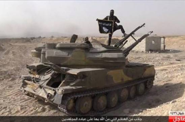 Imagen publicada en Facebook desde la página Rased Newa Network, afiliada al Estado Islámico. En la captura se puede ver a un militante sobre un tanque de las fuerzas sirias en la ciudad de Quariatain.-AP