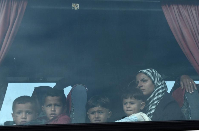 Una mujer y sus hijos, a bordo del autobús que les ha sacado del campo de Idomeni, esta mañana.-AP
