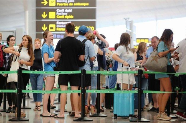 Pasajeros esperan para pasar los controles de seguridad en el aeropuerto de El Prat.-JOAN CORTADELLAS