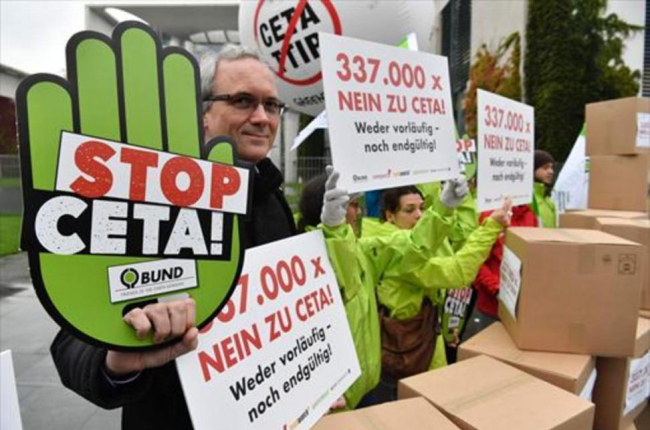 Ciudadanos contrarios al CETA y el TTIP se manifiestaron delante de la Cancillería alemana, en Berlín.-AFP / JOHN MACDOUGALL
