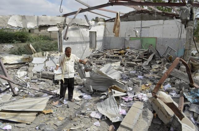 Un hombre intenta rescatar algunas pertenencias de un edificio en Bajil (Yemen) destruido por la coalición árabe.-ABDULJABBAR ZEYAD / REUTERS