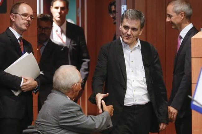 El ministro de Finanzas griego, Euclides Tsakalotos (derecha) estrecha la mano de su homólogo alemán, Wolfgang Schäuble, este viernes, en Bruselas.-Foto:   EFE / OLIVIER HOSLET