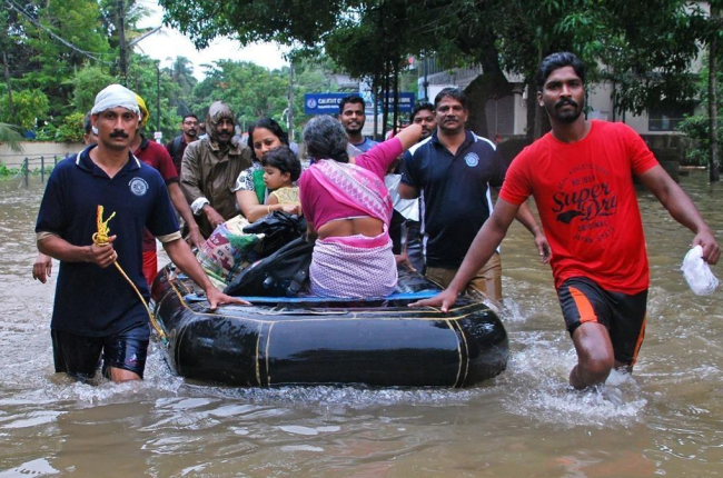 Voluntarios ayudan a evacuar a vecinos de las zonas inundadas en Kozhikode. /-AFP