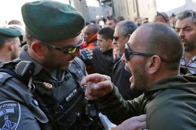 Un palestino se enfrenta a un policía israelí en Jerusalén.-THOMAS COEX / AFP