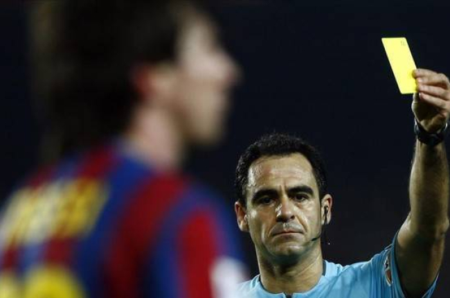 Velasco Carballo muestra una tarjeta amarilla a Messi.-Foto: REUTERS