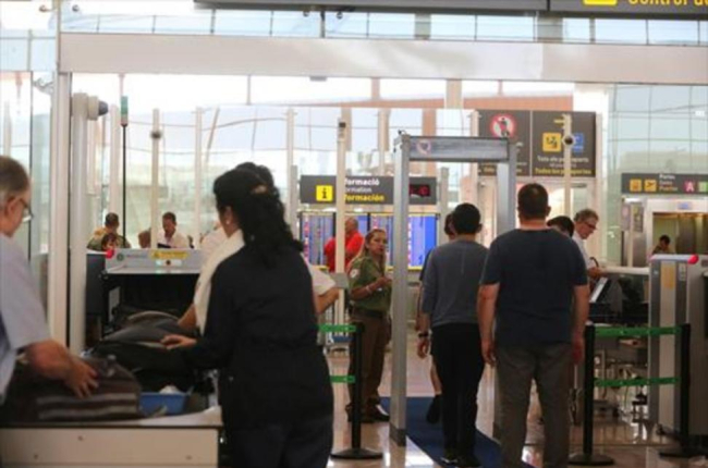 Una trabajadora de Eulen controla el paso por un arco detector de metales en la T-1, el pasado 24 de julio.-/ ELISENDA PONS