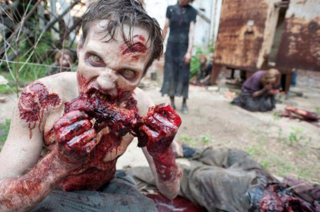 Uno de los zombis de la serie The walking dead, devorando a una de sus víctimas.-EL PERIÓDICO