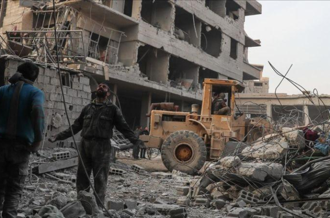 Civiles y voluntarios de la Defensa Civil Siria buscan sobrevivientes tras varios ataques aéreos en la ciudad de Hamoria, en Guta.-EFE / MOHAMMED BADRA