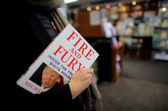 Una mujer sostiene un ejemplar de Fire and Fury, en una librería de Washington (EEUU).-CARLOS BARRIA (REUTERS)