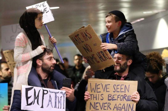 Adin y Meryem sentados sobre los hombros de sus padres, Jordan Bendant-Appell, un rabino, y Faith Yildrim, un musulmán, en una manifestación en Chicago.-Chicago Tribune