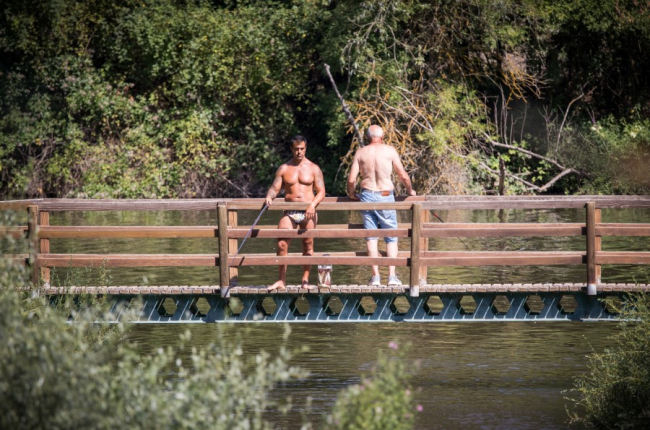 Dos pescadores ligeros de ropa en el Duero durante una ola de calor del pasado año. GONZALO MONTESEGURO