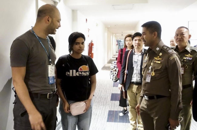 Rahaf, junto a oficiales de inmigración de la ONU en el aeropuerto de Bangkok.-AFP