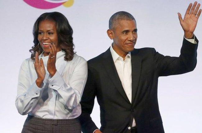 El matrimonio Obama posa sonriente tras firmar el acuerdo con con la plataforma de música en streaming Spotify.-AP / CHARLES REX