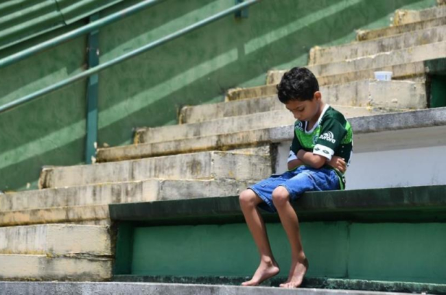 Un niño llora a sus ídolos desaparecidos en el estadio del Chapecoense.-AFP / NELSON ALMEIDA