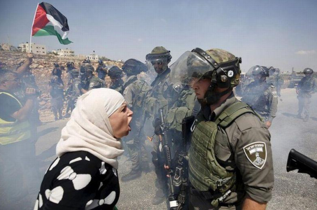 Una mujer palestina discute con un policía fronterizo israelí durante una protesta contra los asentamientos judíos en la aldea cisjordana de Nabi Saleh, cerca de Ramallah.-REUTERS / MOHAMAD TOROKMAN