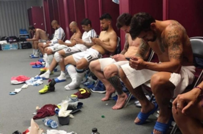 Los jugadores de Argentina, pendientes de sus teléfonos móviles tras la victoria sobre Venezuela.-INSTAGRAM