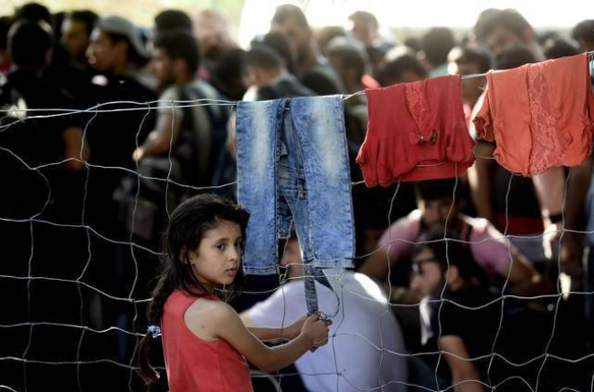 Una refugiada siria fotografiada frente a una valla fronteriza con Serbia el pasado domingo.-AFP / ARIS MESSINIS