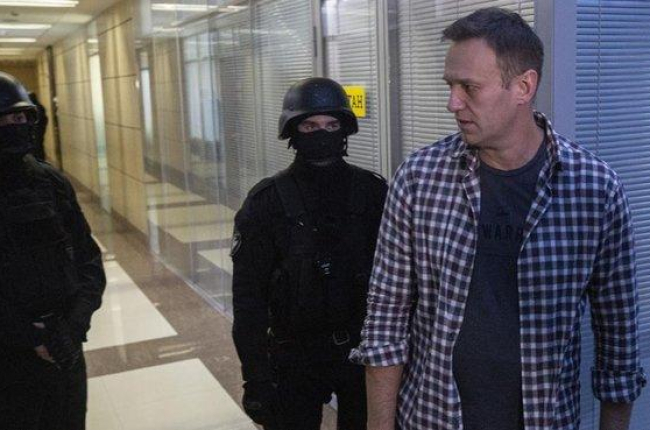Alexei Navalni, en sus oficinas con dos policías, ayer.-EFE EPA SERGEI ILNITSKY