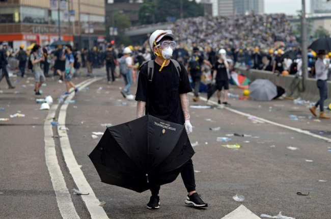 Un protestante porta un paraguas durante las manifestaciones masivas contra la polémica ley de extradición, este miércoles en Hong Kong (China).-EFE/ VERNON YUEN