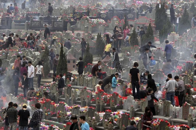 Familiares visitan las tumbas de sus seres queridos en un cementerio de la ciudad china de Jinjiang.-AP